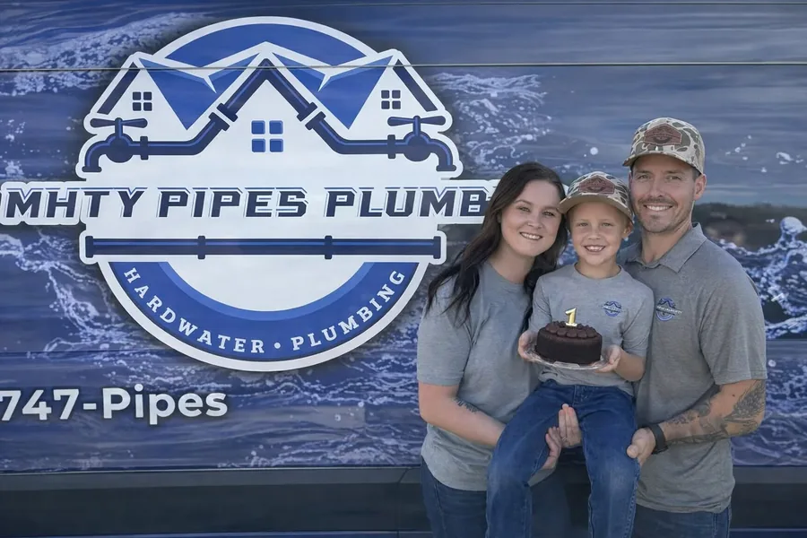 The Mighty Pipes Plumbing family in front of their branded service truck